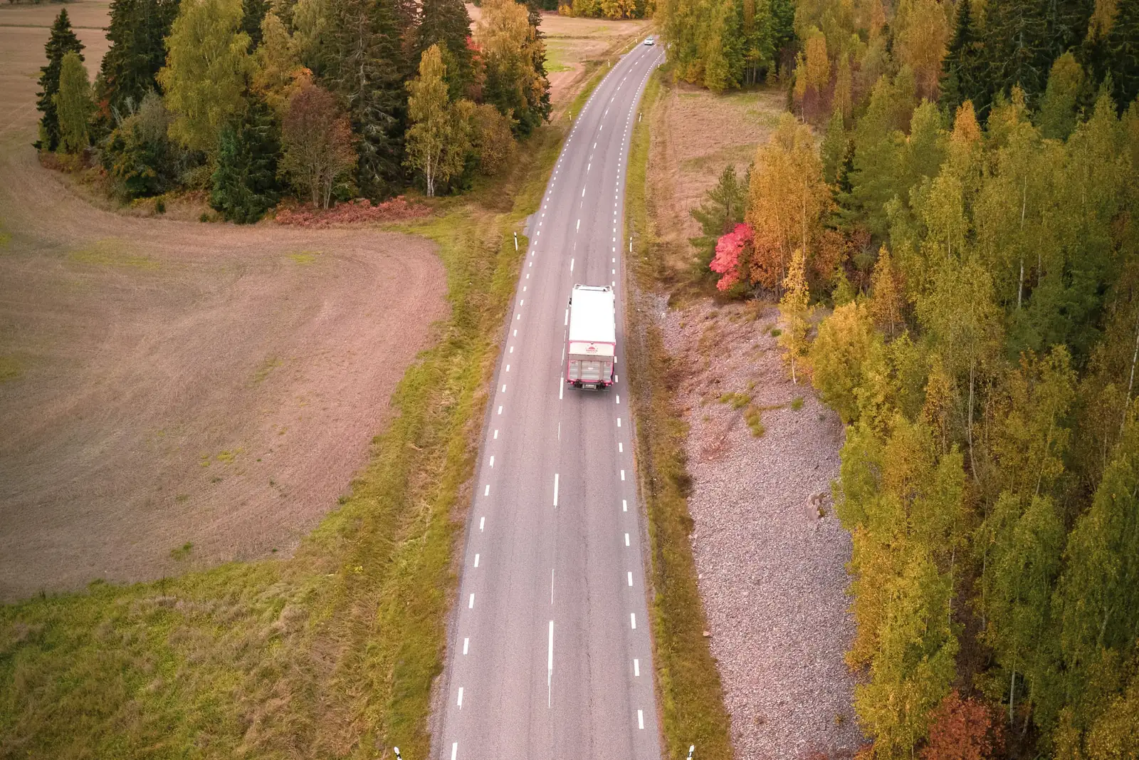 Trucks travelling at night on a motorway, aerial view.